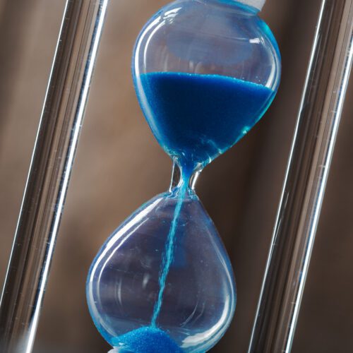 time is passing blue hourglass close up scaled